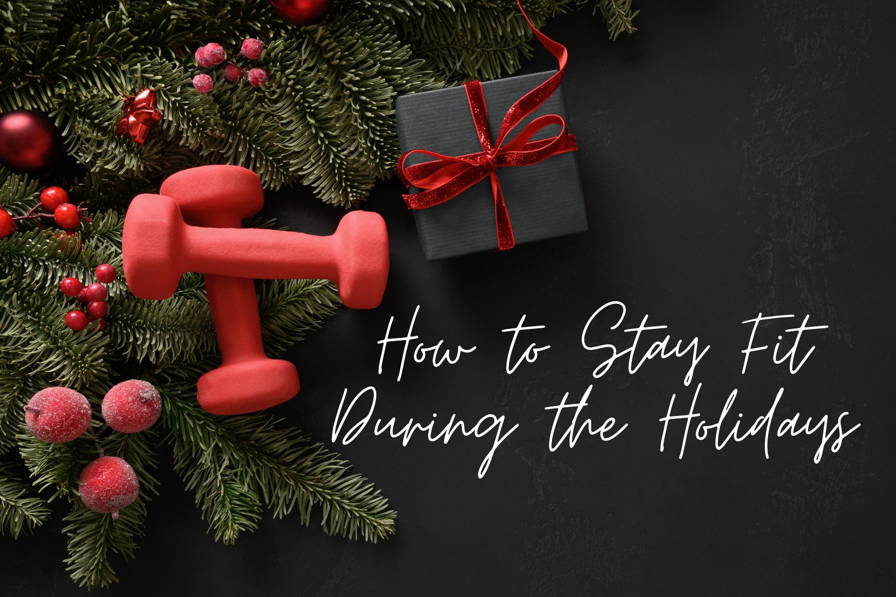 Red dumbbells placed on festive holiday greenery with ornaments and a gift box, symbolizing staying fit during the holidays.